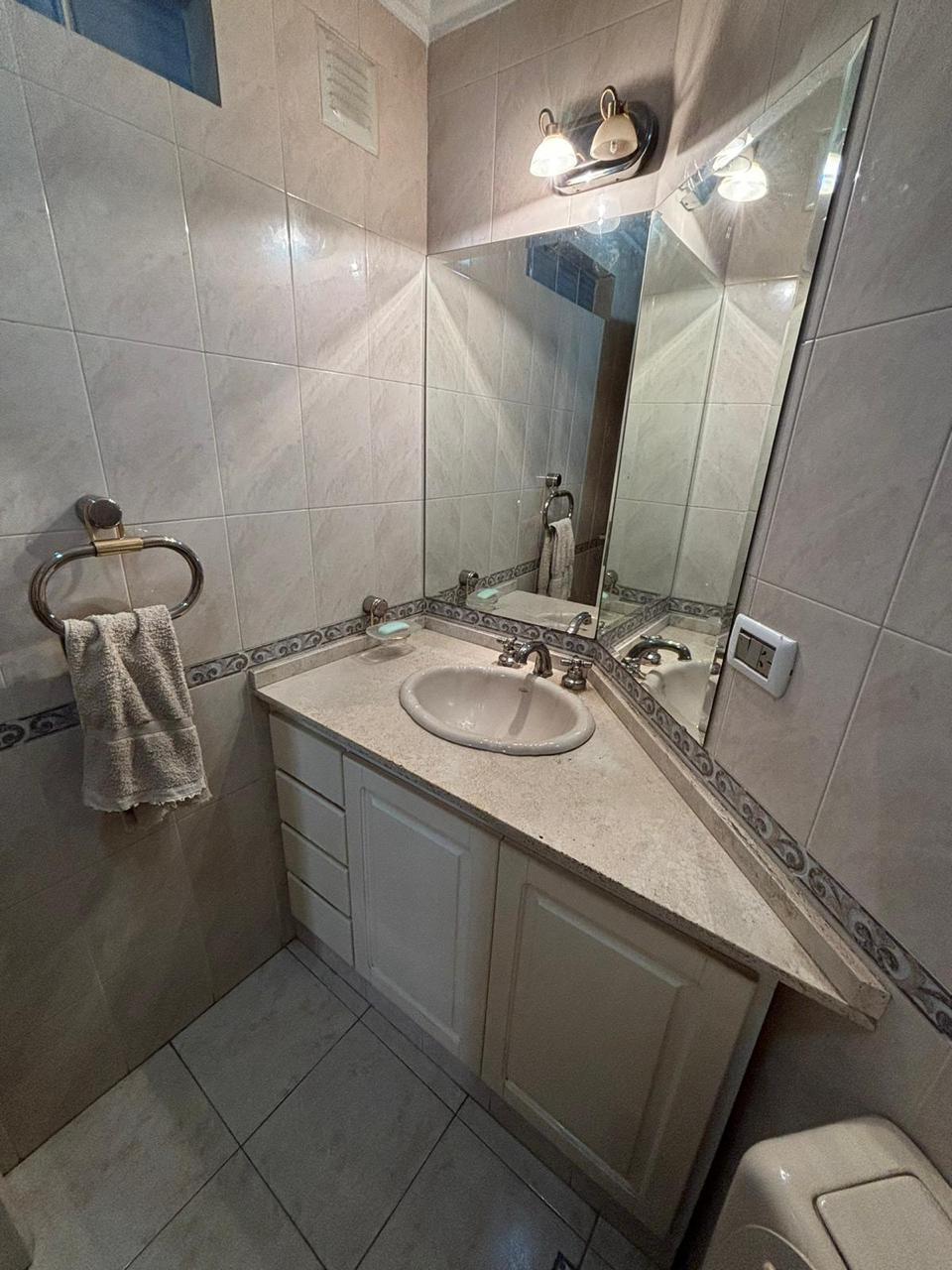 Baño con vanitory esquinero