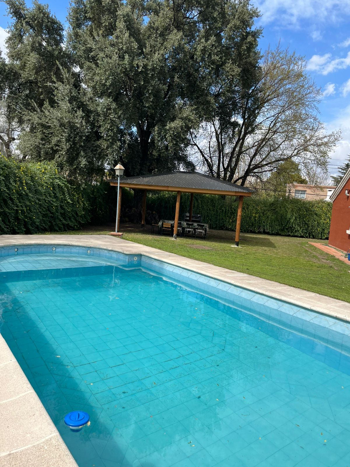 Pileta con quincho de fondo