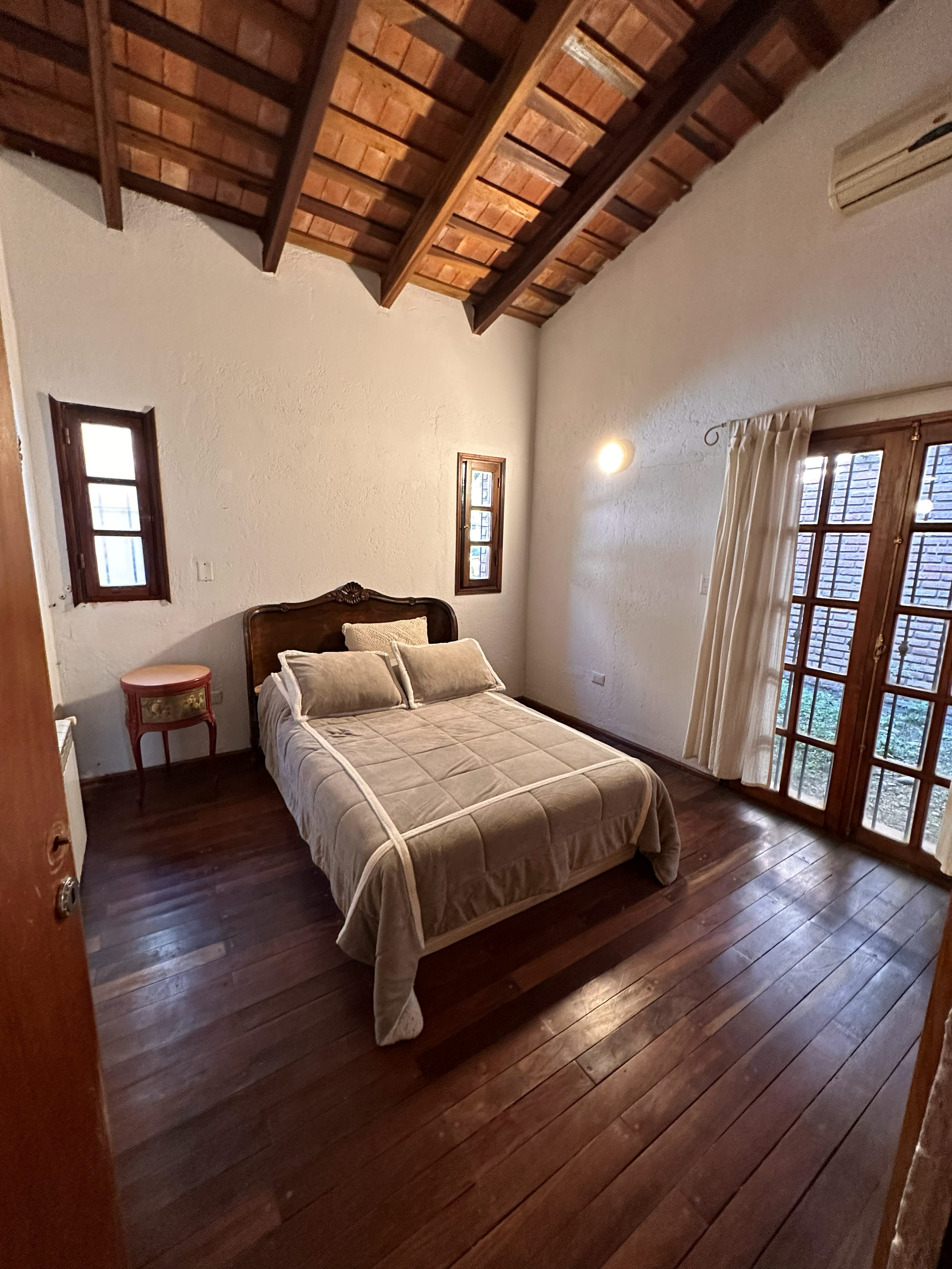 Dormitorio con cabecera de madera tallada